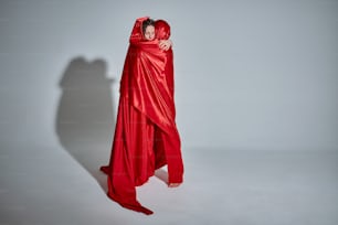 a woman in a red dress is wrapped in a red cloth