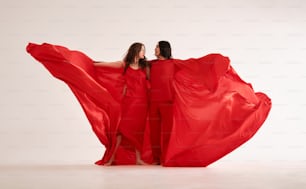 two women in red dresses are posing for a picture