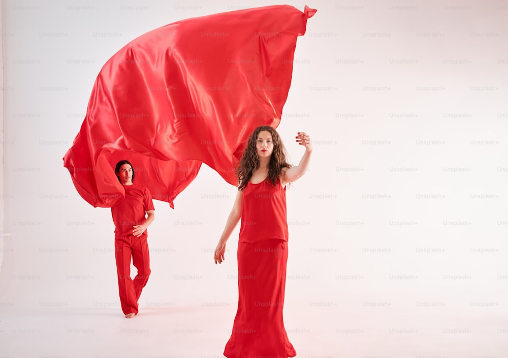 a woman in a red dress holding a red cloth