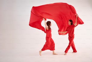 a couple of people that are holding a red cloth