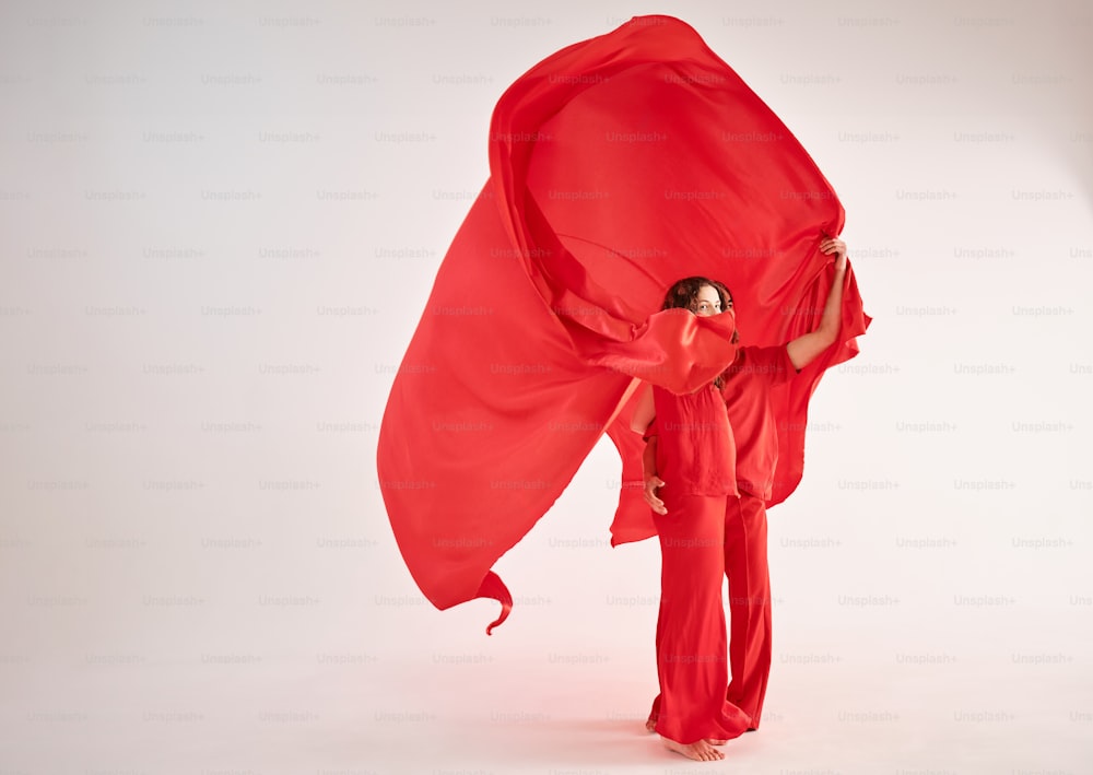 a woman in a red outfit holding a red cloth