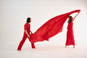 a woman in a red dress holding a red cloth