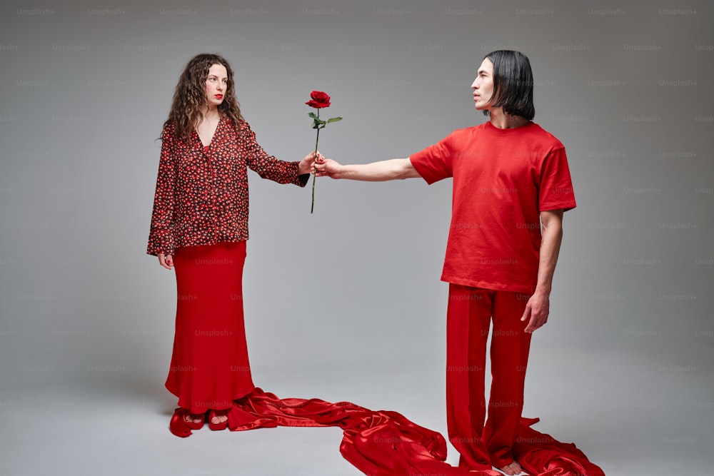a man and a woman are holding a rose