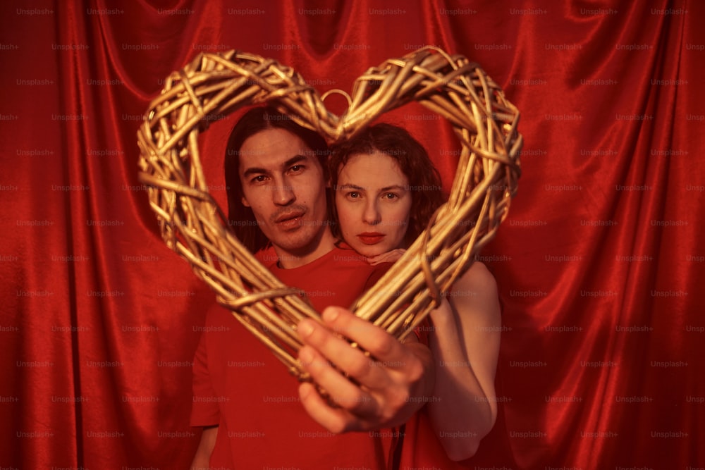 a man and woman holding a heart shaped basket