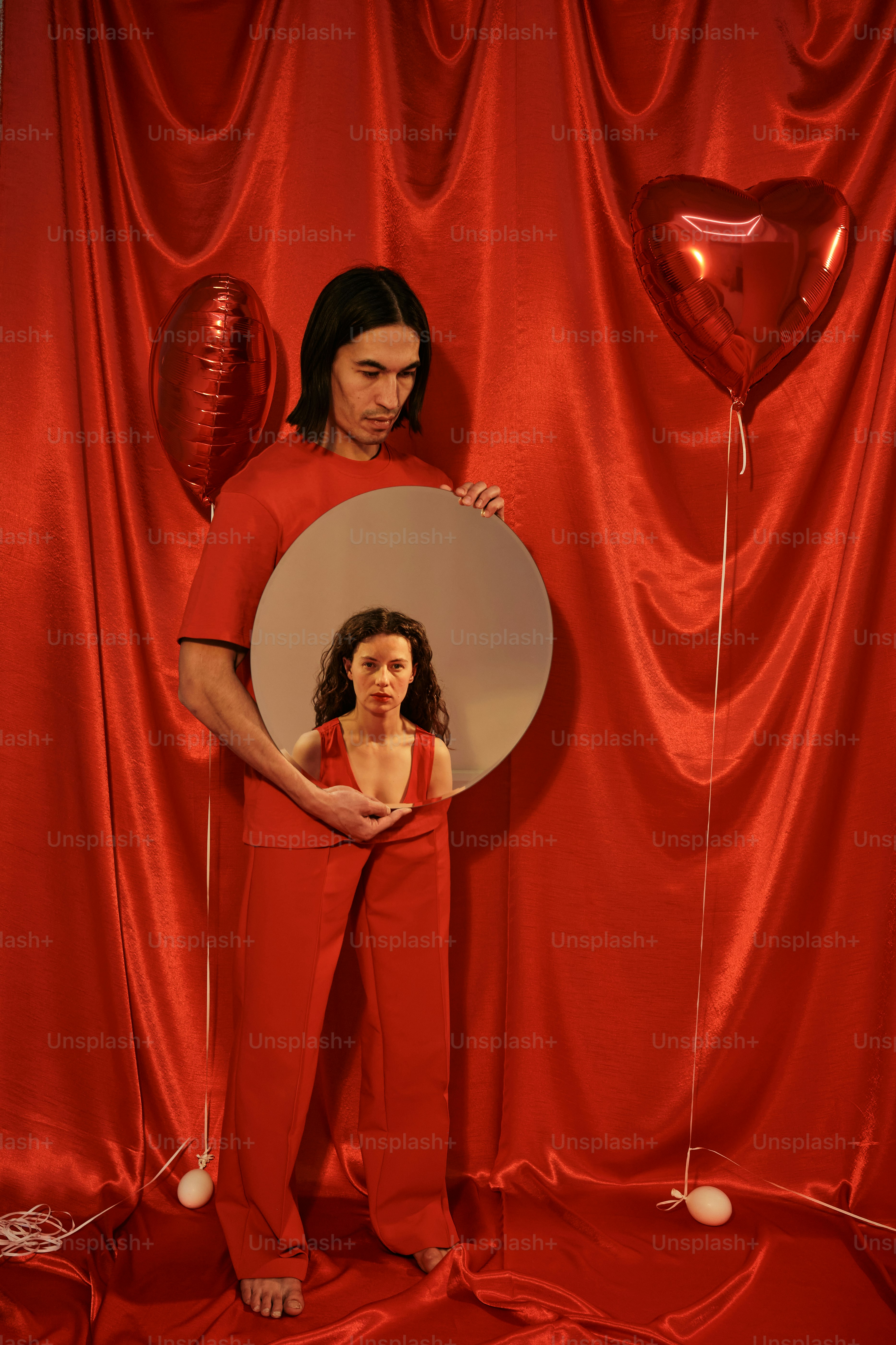 a man and a woman standing in front of a mirror