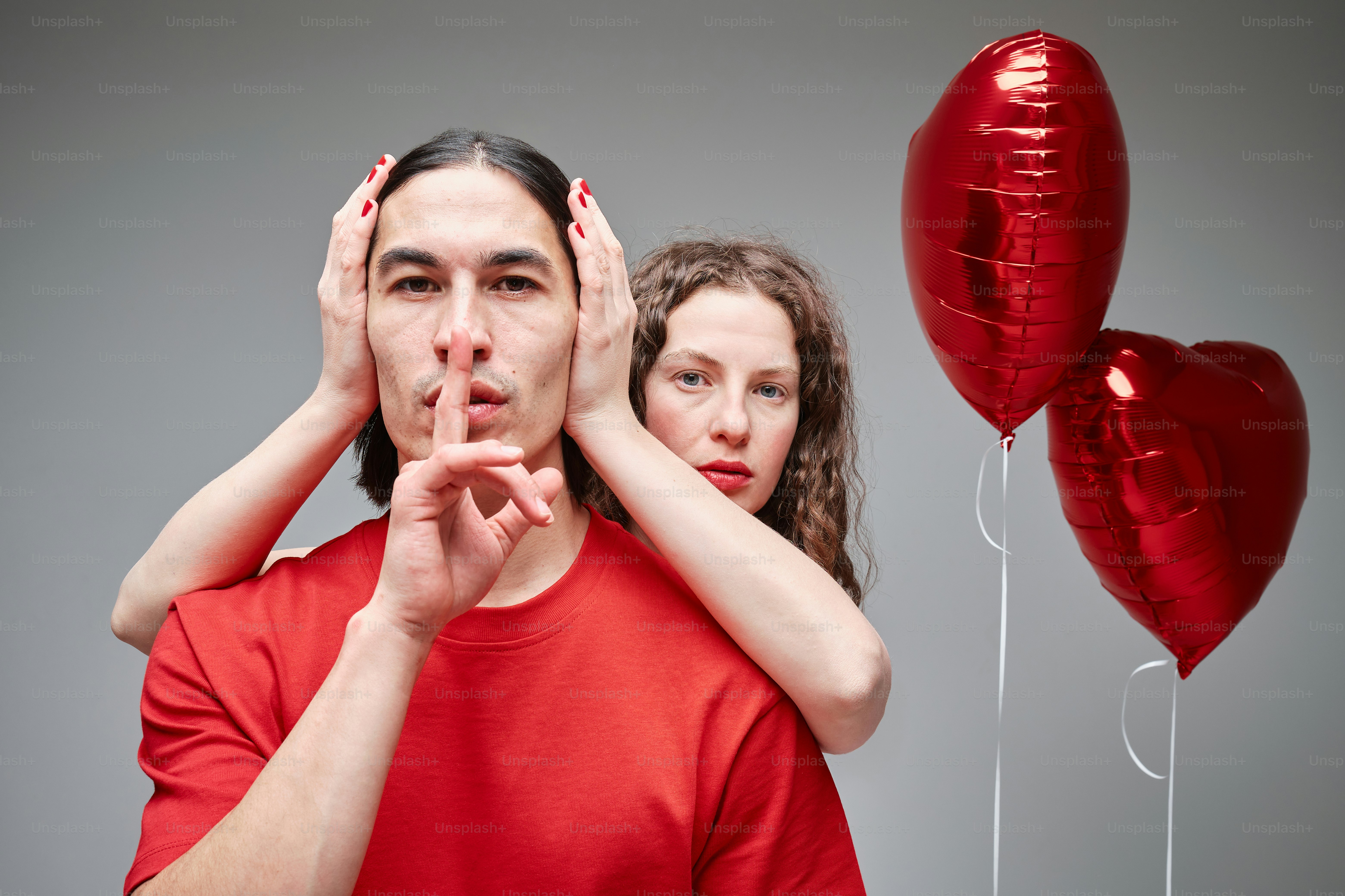 a man and a woman covering their faces with their hands