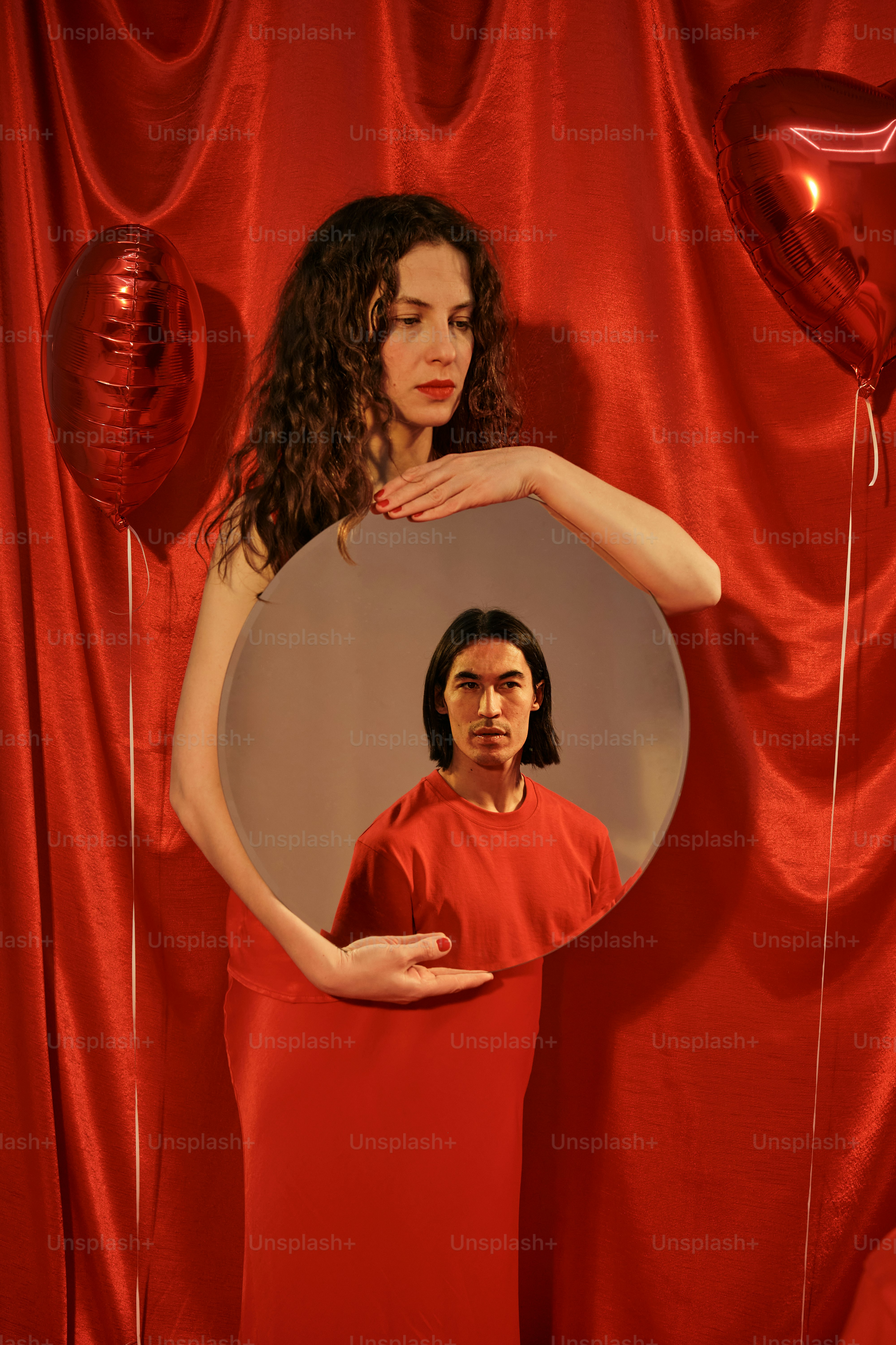 a woman in a red dress standing in front of a mirror