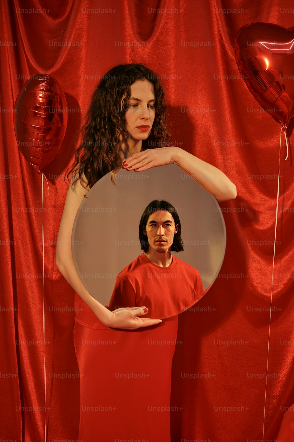 a woman in a red dress standing in front of a mirror