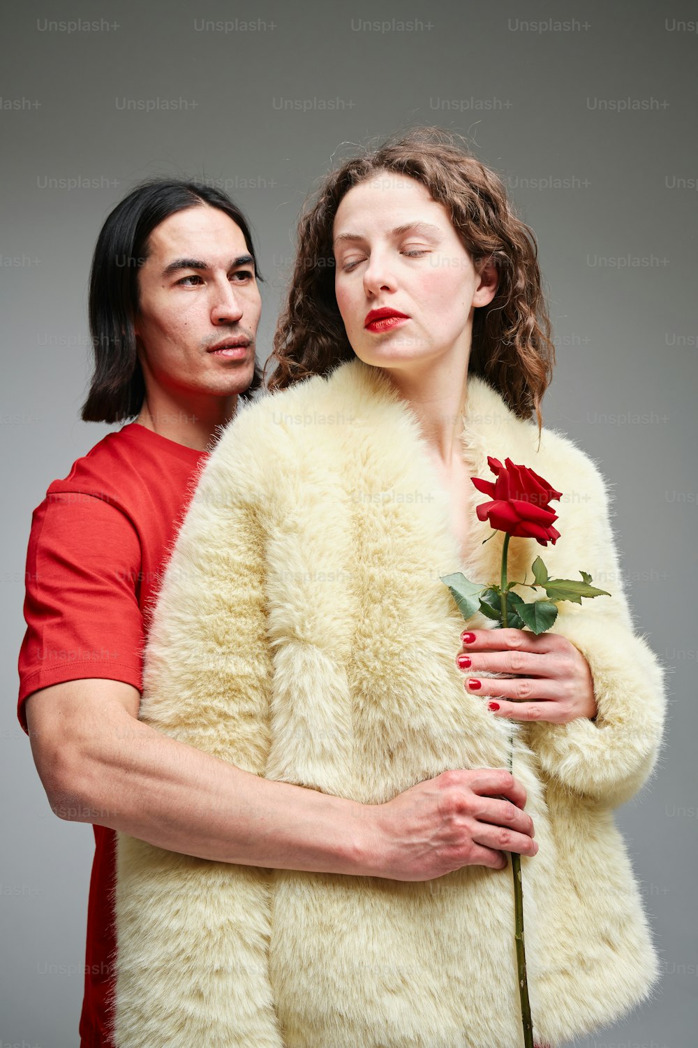 a man holding a rose next to a woman