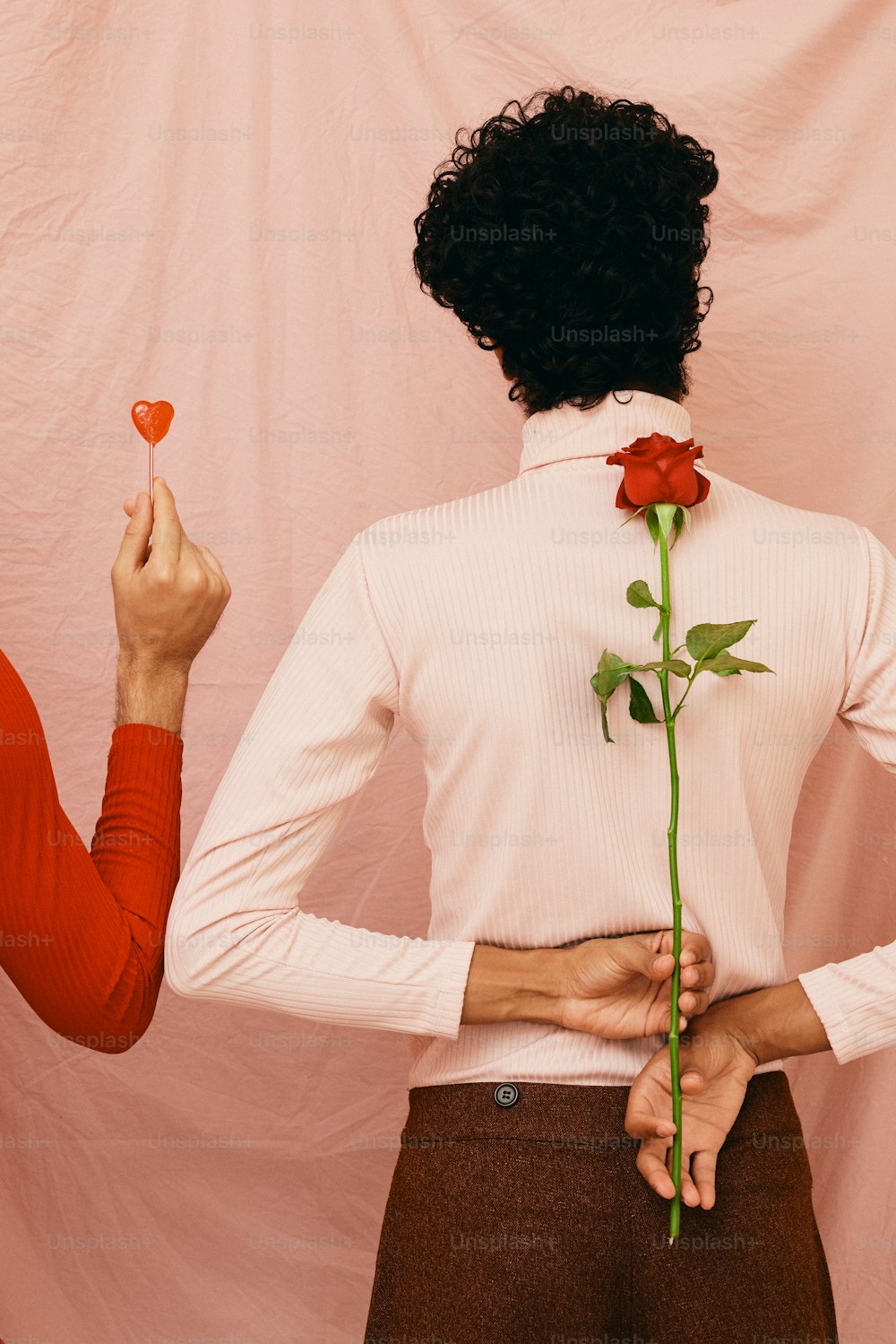 una mujer sosteniendo una rosa y un hombre sosteniendo un corazón