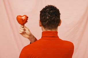 a man holding a heart shaped object in his hand
