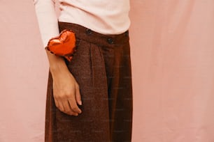 una mujer sosteniendo un objeto en forma de corazón en su mano