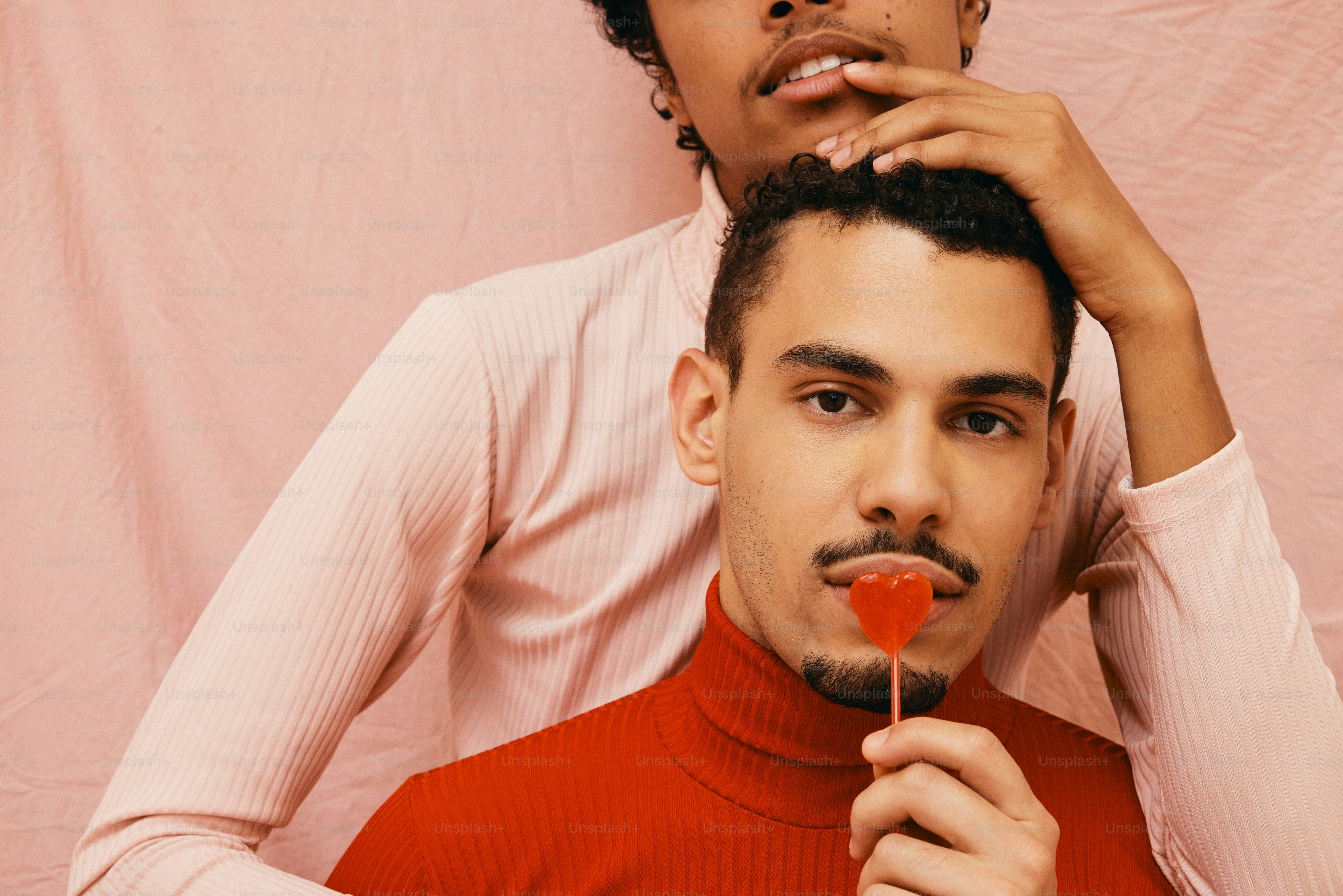 um homem segurando um pirulito na frente do rosto