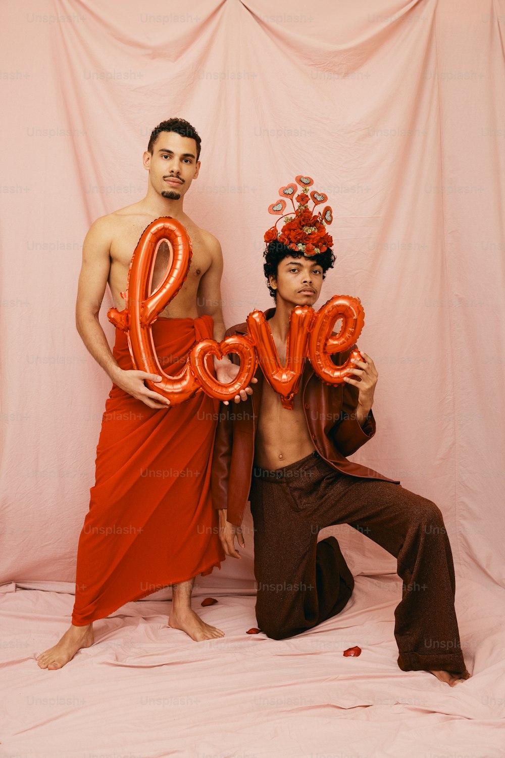 a couple of men standing next to each other holding balloons