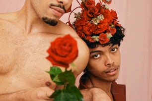 ein Mann mit einer Blumenkrone auf dem Kopf neben einem Mann mit einer Rose