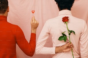 ein Mann hält eine Rose vor einer Frau