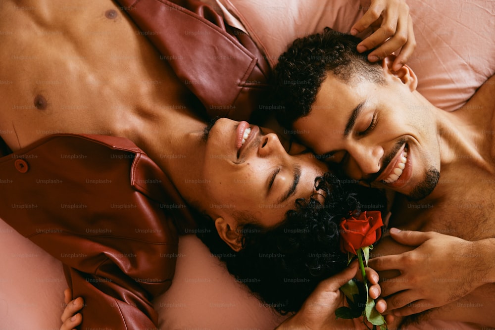 a man laying on a bed with a rose in his hand
