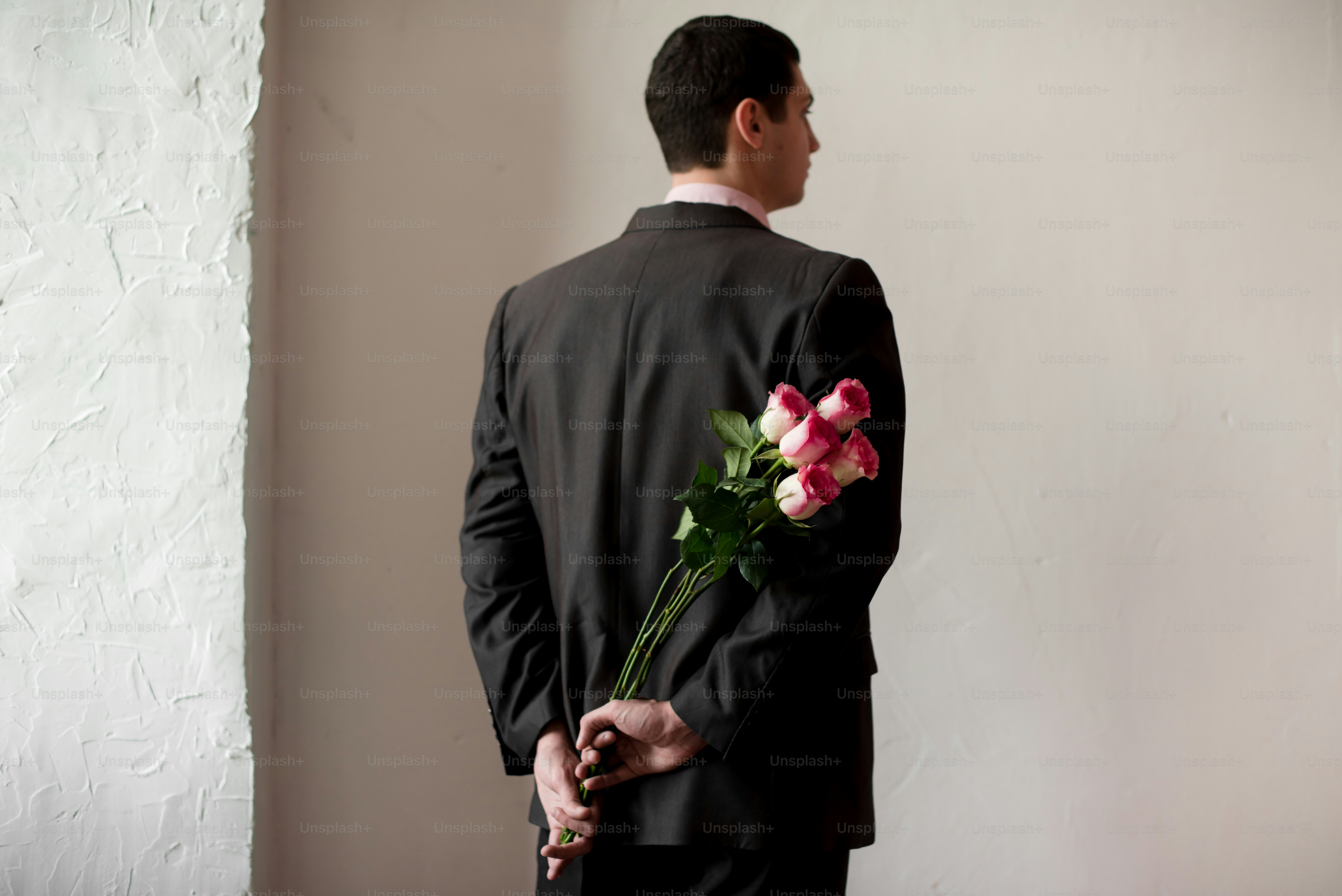 A man in a suit holding a bouquet of flowers photo – Flower Image on ...