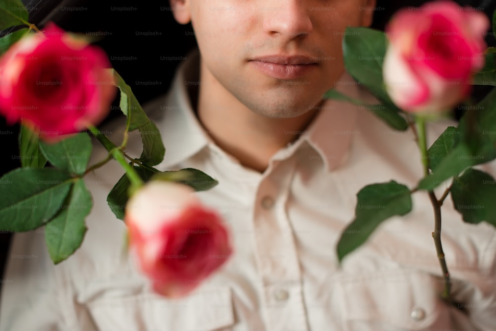 a man is holding roses in his hands