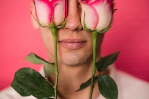 un homme avec trois roses devant son visage