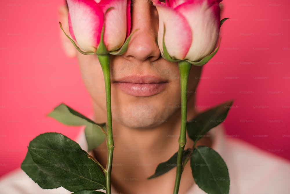 Ein Mann mit drei Rosen vor dem Gesicht