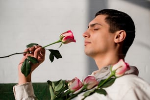 un homme tenant une rose à son visage