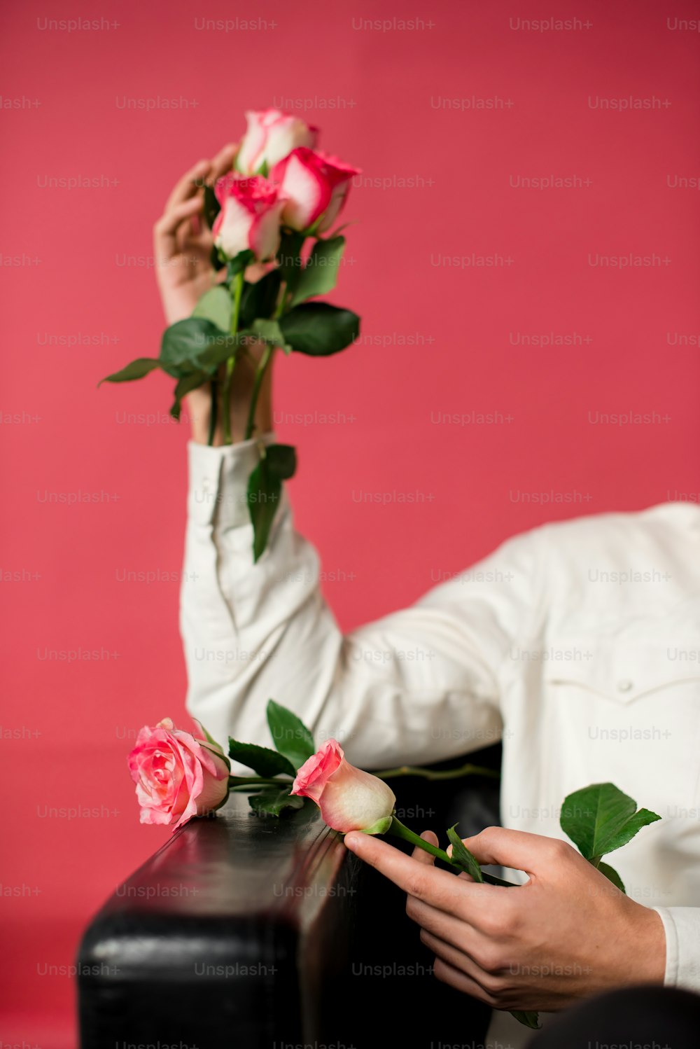 a woman holding a bunch of roses in her hand