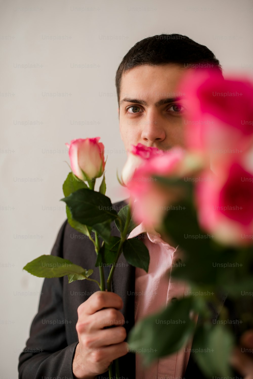 Ein Mann hält einen Rosenstrauß vor sein Gesicht