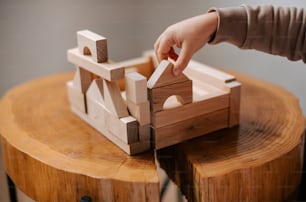 Eine Person spielt mit einem Holzspielzeug