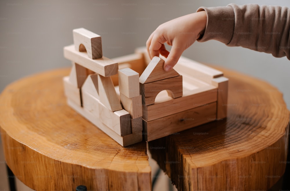 a person is playing with a wooden toy