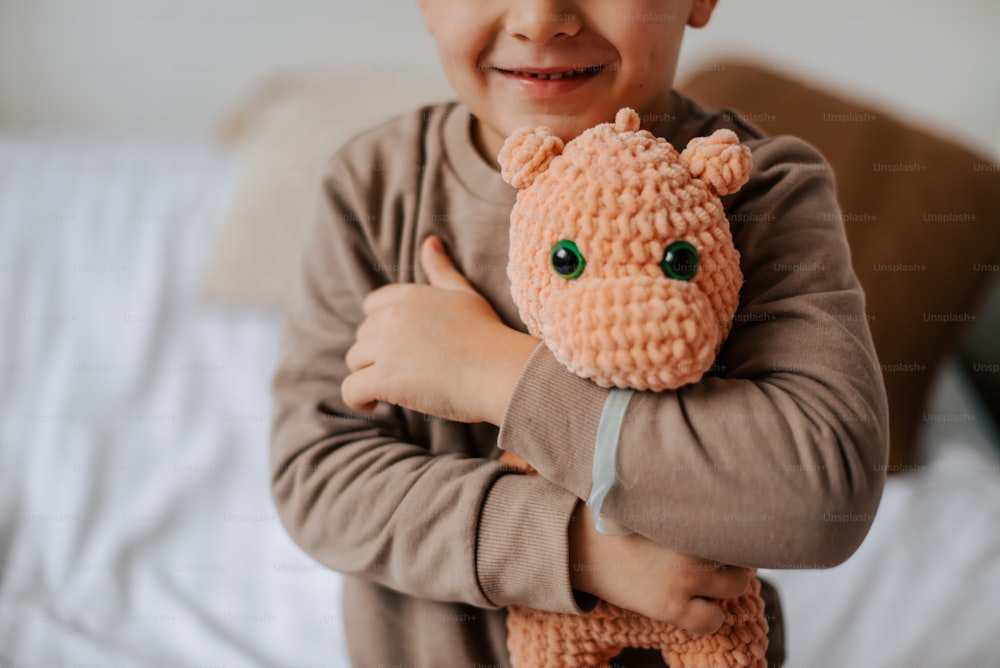 a little boy holding a stuffed animal in his arms