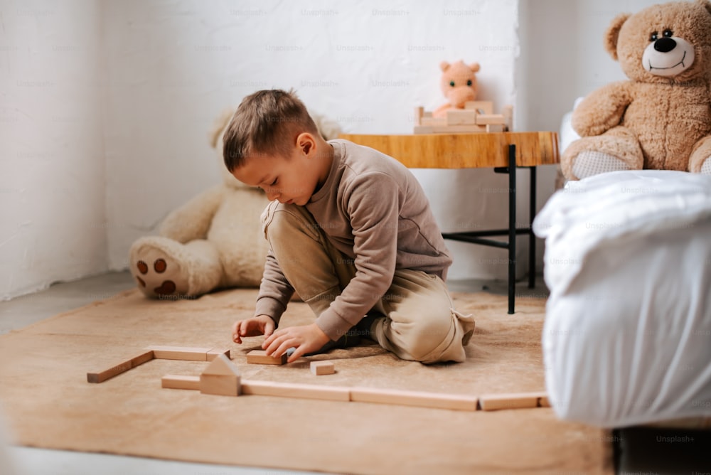 a little boy playing with wooden blocks on the floor