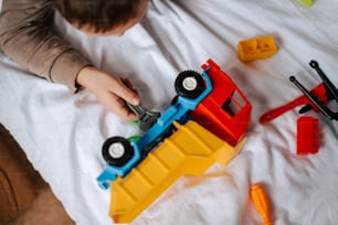 a young boy playing with toys on a bed