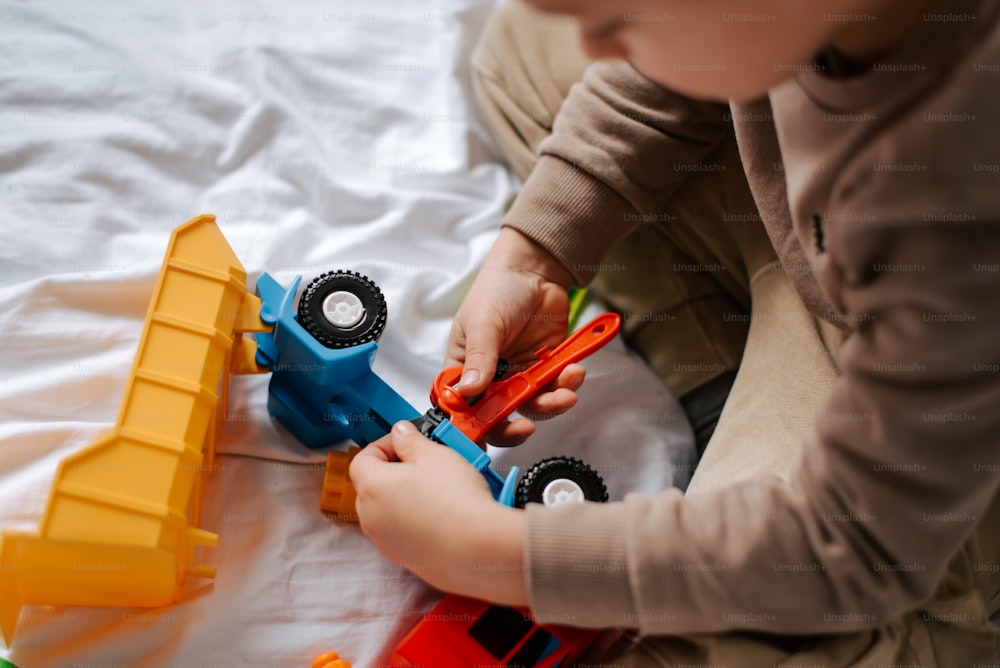 a little boy playing with a toy truck