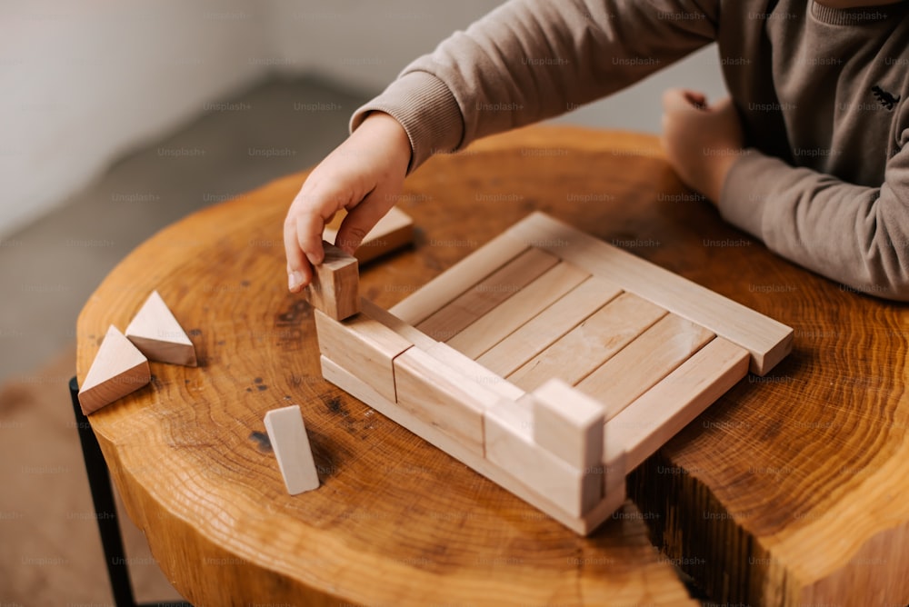 a child is playing with a wooden block set