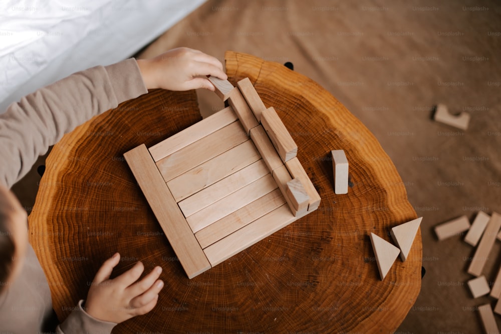 a child playing with wooden blocks on a table