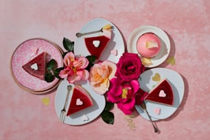 uma mesa coberta com pratos de bolo e flores