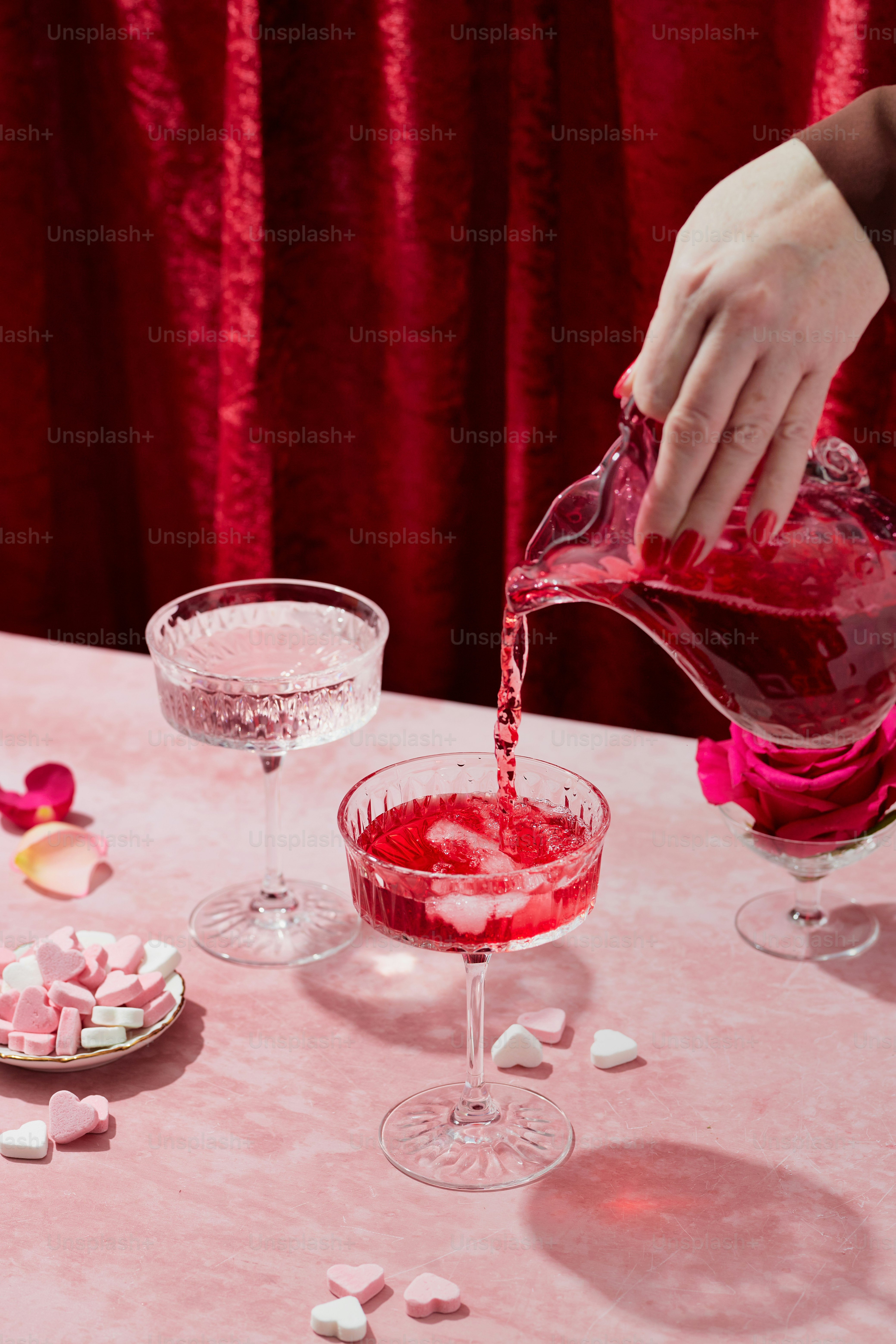 a person pouring red liquid into a glass