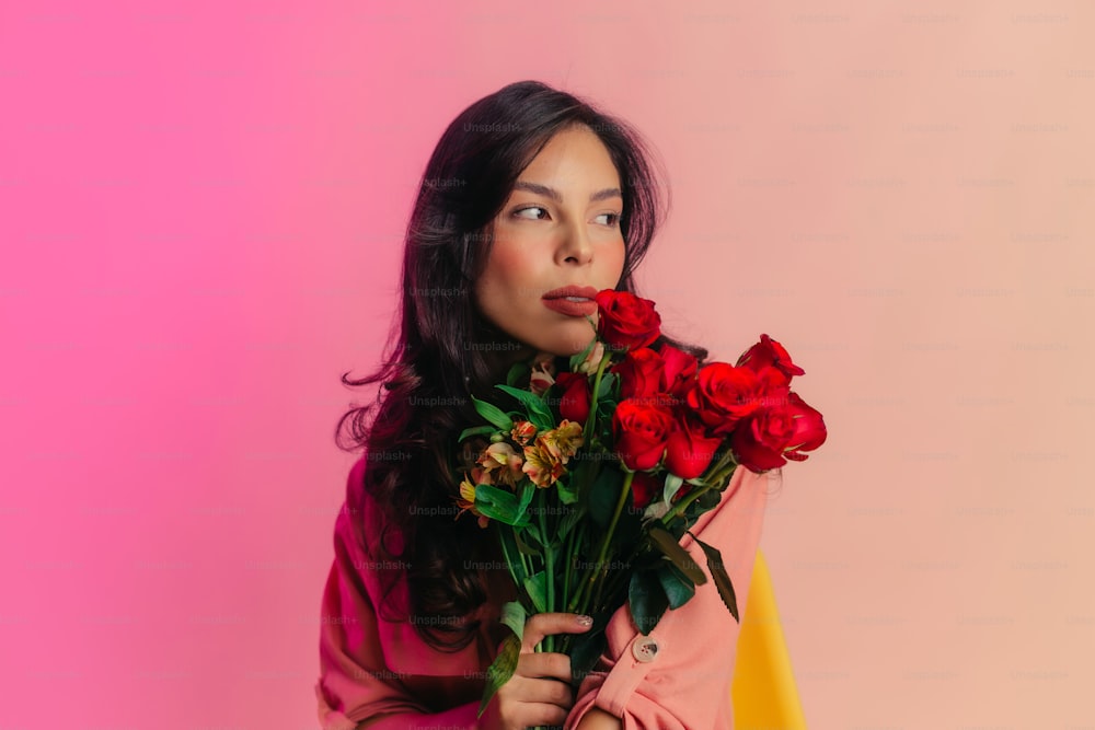 una mujer sosteniendo un ramo de rosas rojas