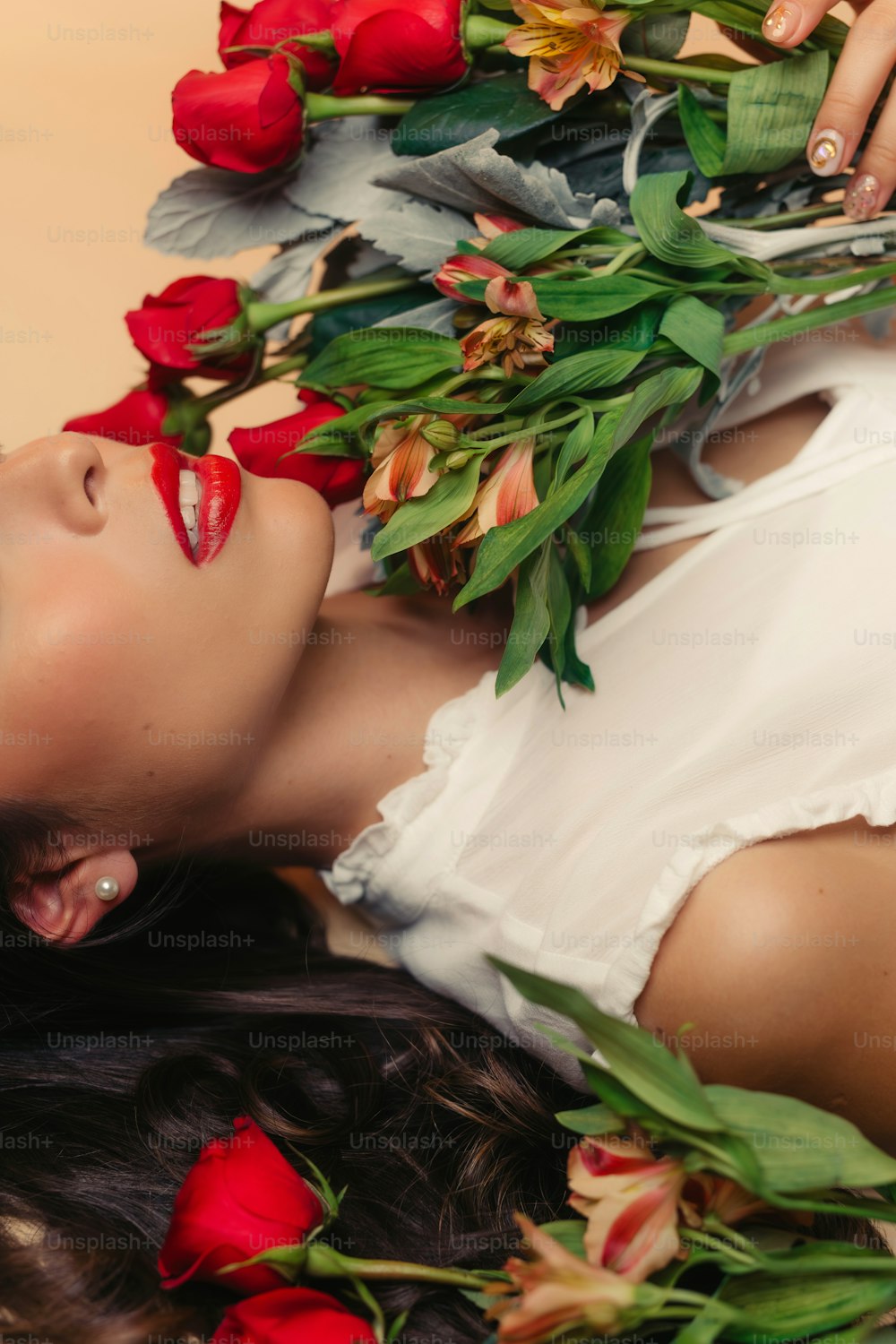 a woman laying on the ground with flowers in her hair