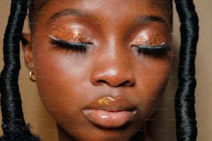 a young girl with gold glitter on her eyes