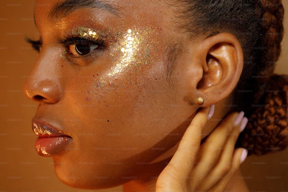 uma mulher com glitter dourado no rosto
