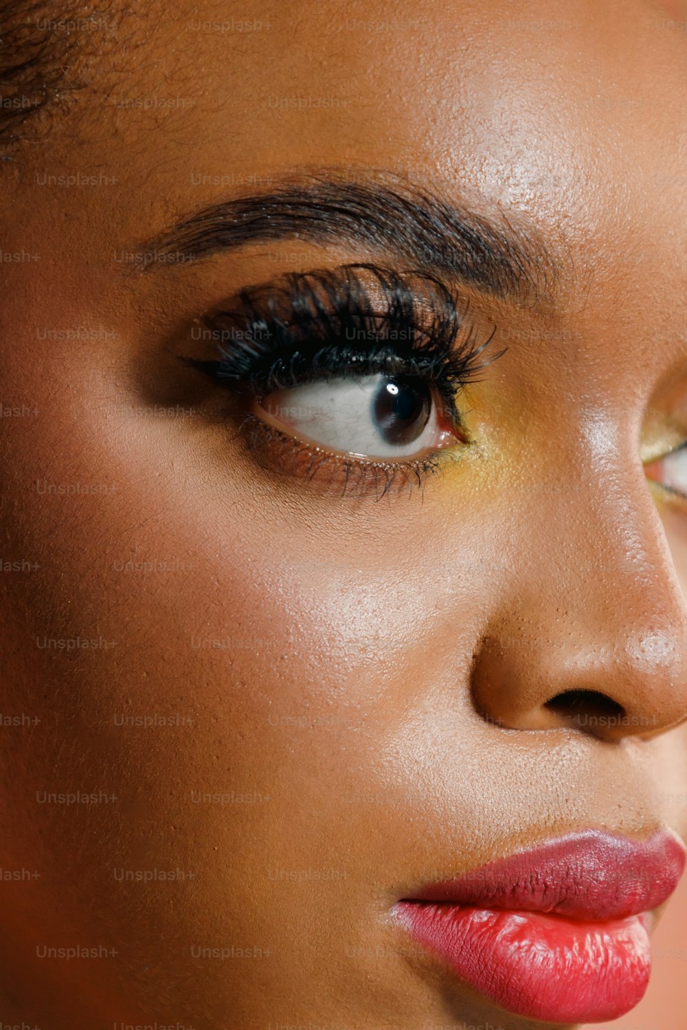 um close up do rosto de uma mulher com maquiagem brilhante