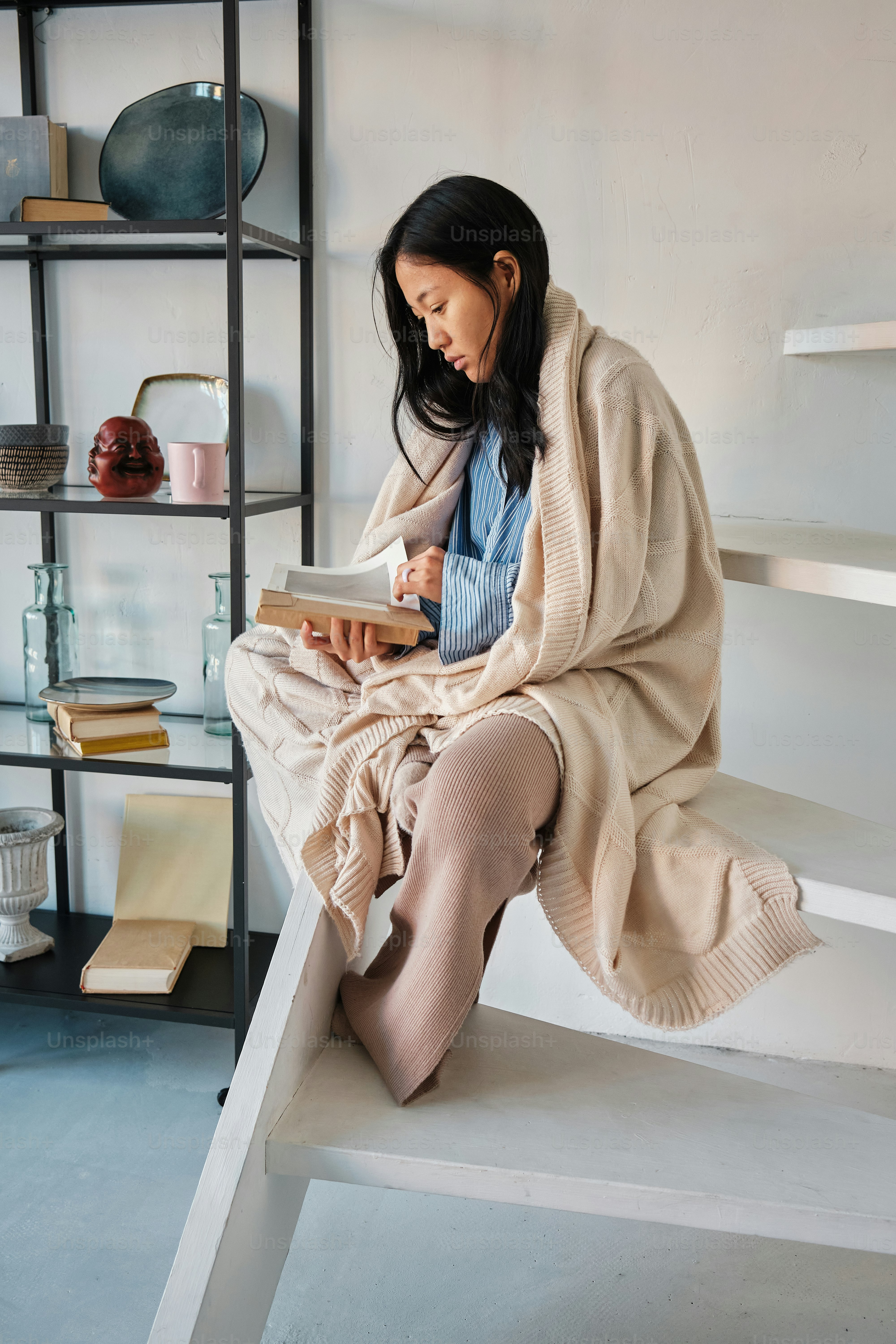 a woman sitting on a step reading a book