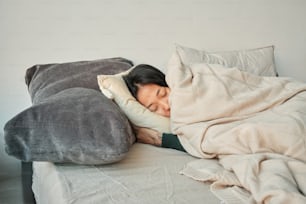 a woman is sleeping on a bed with a pillow