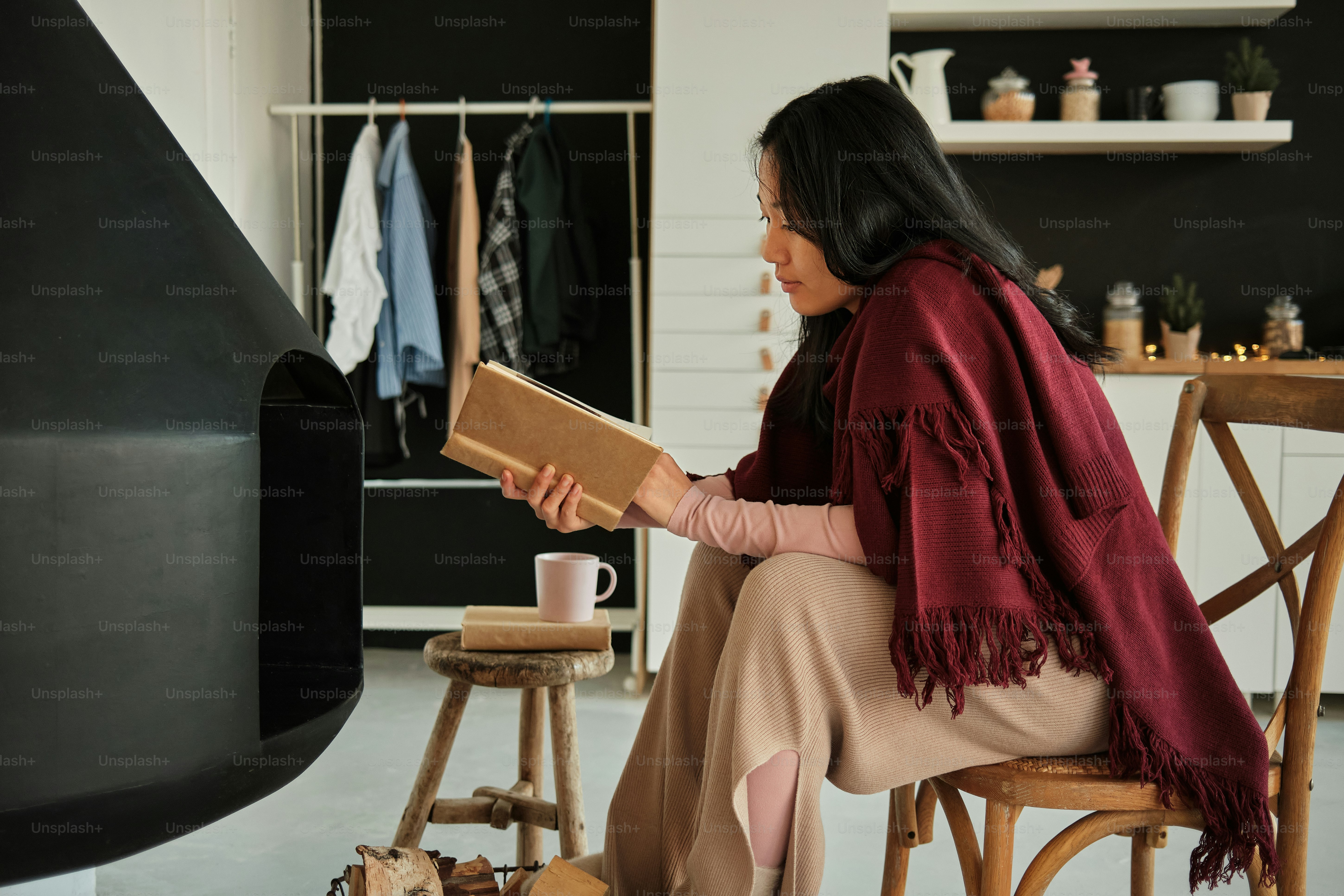 a woman sitting on a chair reading a book