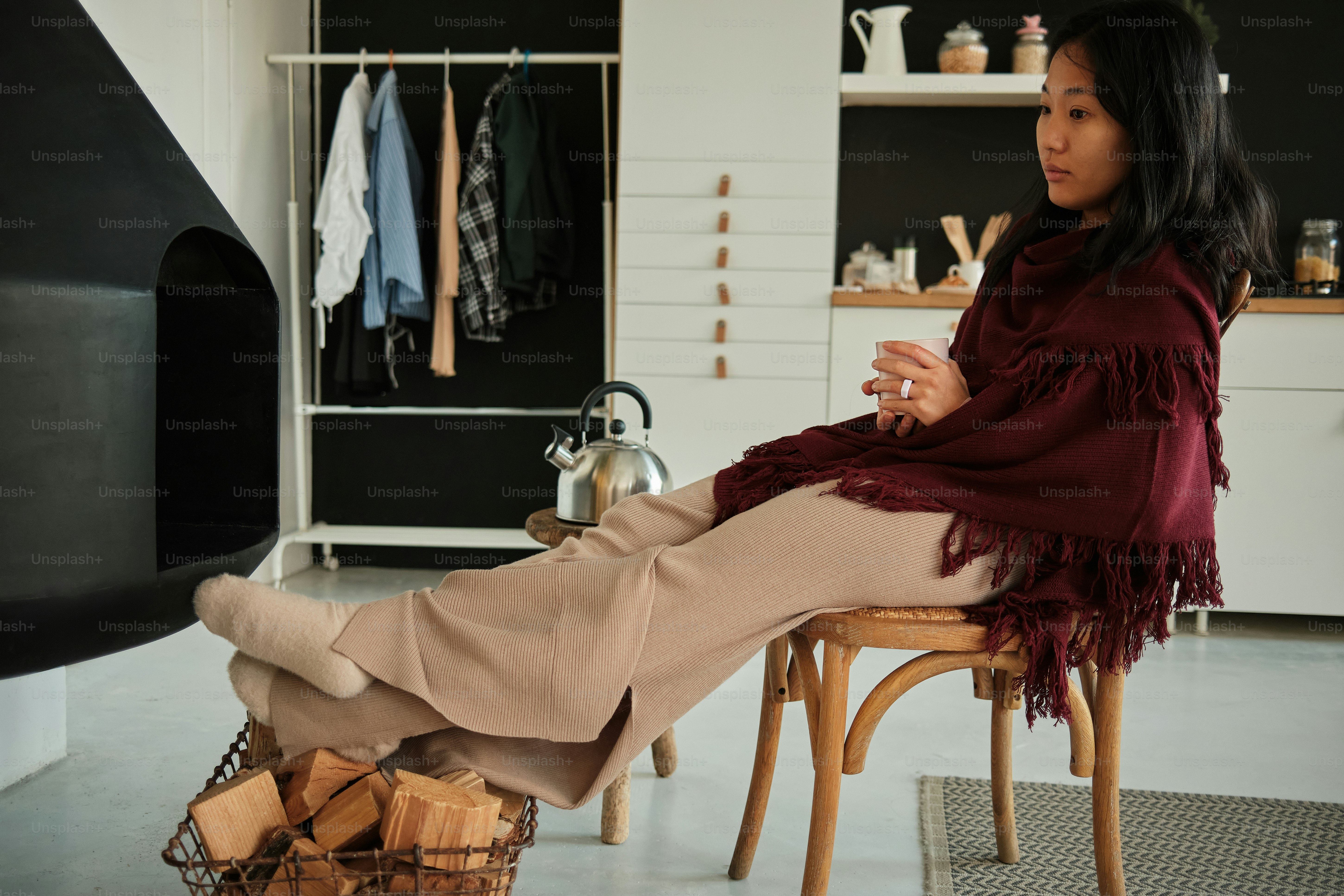 a woman sitting on a chair in front of a fireplace