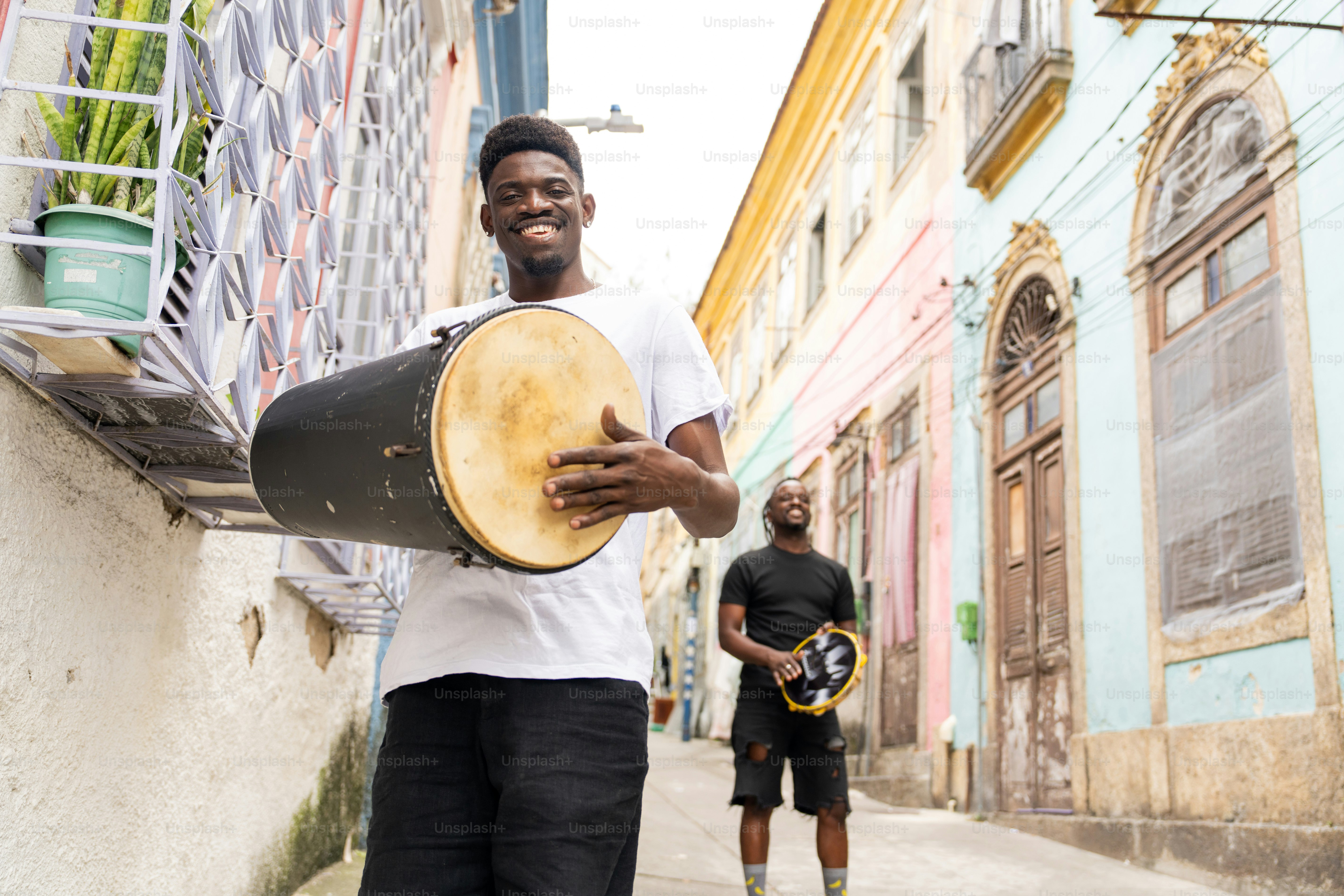 Un homme tenant un grand tambour dans une rue de la ville