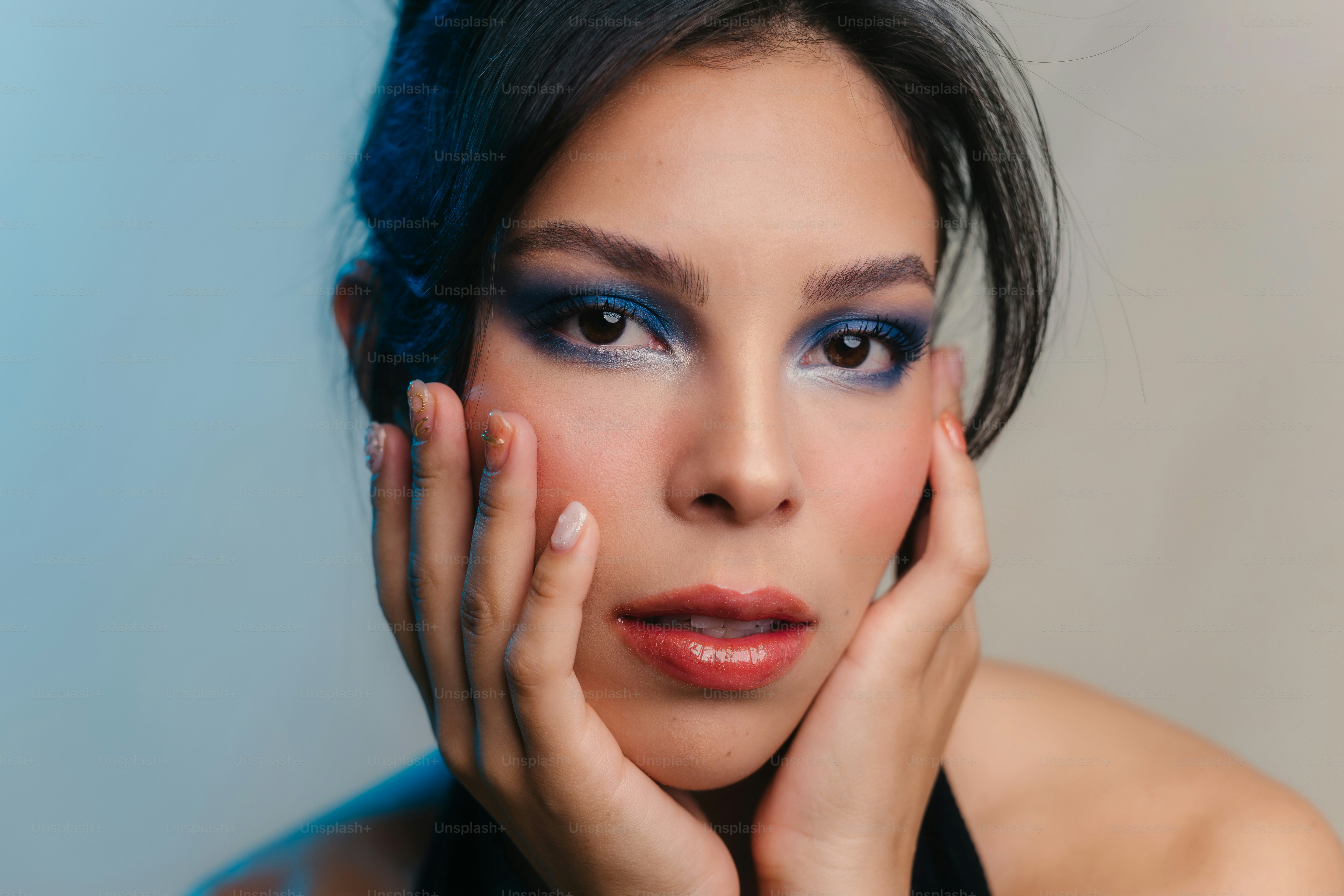 eine Frau mit blauem Make-up posiert für ein Foto