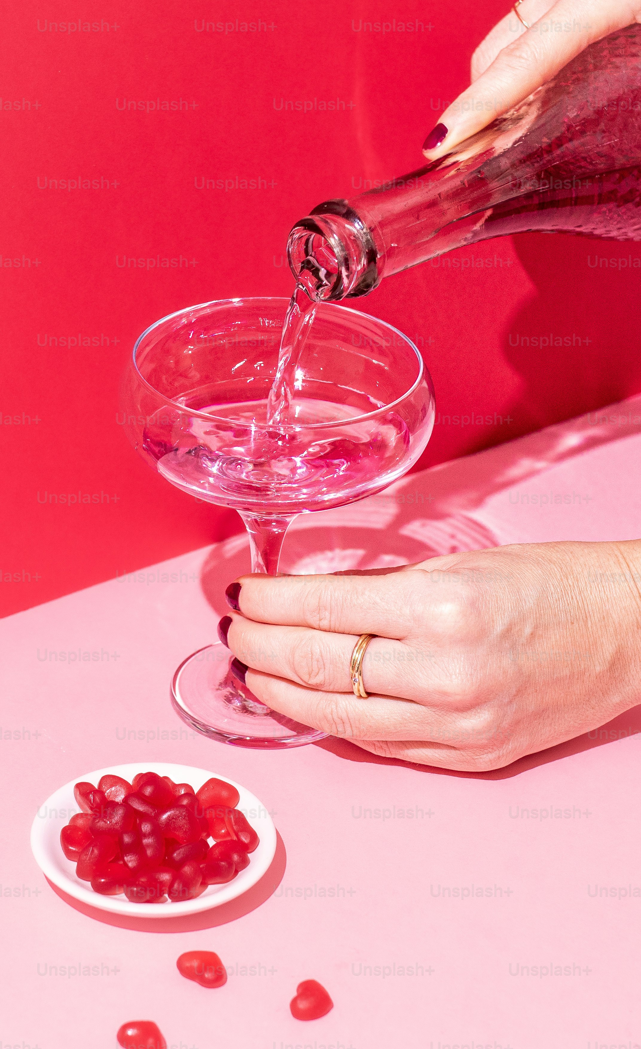 a person pouring a drink into a glass